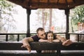 Little girl and her dad leaning on wooden pavilion fence