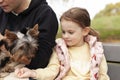 Little girl and her mom playing in the park with a Yorkshire Terrier Royalty Free Stock Photo