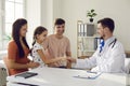 Child shakes hands and meets the family doctor while sitting in the doctor's office. Royalty Free Stock Photo