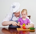 Little girl and her father cutting vegetables