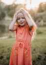 The little girl with her hands on her head and smiles