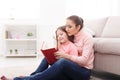 Little girl and her mom reading book at home Royalty Free Stock Photo