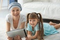 Little girl and her mother after chemotherapy using tablet PC at home Royalty Free Stock Photo