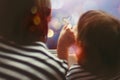 Little girl with her mother drawing heart on misted window glass