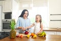 Little girl with her mother in the kitchen preparing a fresh fruit salad Royalty Free Stock Photo