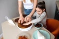 Little girl and her mother putting pieces of cake on each other Royalty Free Stock Photo