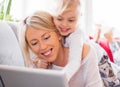 Little girl with her mother using tablet computer