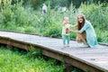 Little girl with her mother on wooden bridge in park Royalty Free Stock Photo