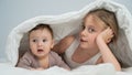 Little girl and her newborn brother hiding under the blanket. Royalty Free Stock Photo