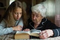 Little girl with her old grandma reading a book Royalty Free Stock Photo