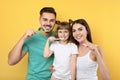 Little girl and her parents brushing teeth together Royalty Free Stock Photo