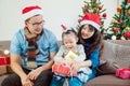 Little girl and her parents open christmas gift boxes Royalty Free Stock Photo