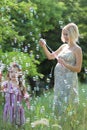 Little girl with her pregnant mommy have fun blowing bubbles Royalty Free Stock Photo