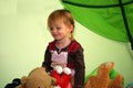 Little girl sits in the middle of all her stuffed animals Royalty Free Stock Photo