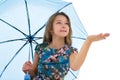 The little girl hid under an umbrella and held out her hand. The girl is watching whether rain is dripping. The concept Royalty Free Stock Photo