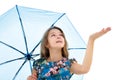 The little girl hid under an umbrella and held out her hand. The girl is watching whether rain is dripping. The concept Royalty Free Stock Photo