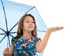 The little girl hid under an umbrella and held out her hand. The girl is watching whether rain is dripping. The concept Royalty Free Stock Photo