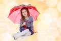 Little girl hiding under an umbrella.