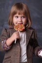 Little girl hold a colorfull lollipop. Little child with sweet lollipop. Happy candy girl. Enjoying