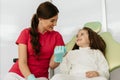 Little girl holding an artificial model of human jaw with dental braces in orthodontic office, smiling. Pediatric