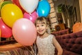 Little girl holding balloons. The child smiles cheerfully on a holiday. Royalty Free Stock Photo