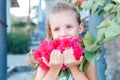 Little girl is holding beautiful pink flowers. bougainvillea