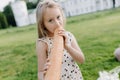 A little girl is holding a big loaf of bread. Funny happy child bites and eats healthy bread, outdoors. Hungry child. Royalty Free Stock Photo
