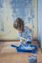 Little girl holding canister with paint at her room, making renovation. Royalty Free Stock Photo