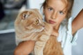 Little girl holding cat in her arms at home indoor, Child playing with domestic animals pet Royalty Free Stock Photo