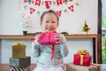 Little girl holding chirstmas day gift box and smiles