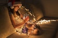 Little girl holding Christmas lights