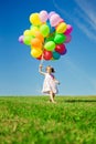 Little girl holding colorful balloons. Child playing on a green Royalty Free Stock Photo