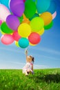 Little girl holding colorful balloons. Child playing on a green Royalty Free Stock Photo