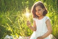 Little Girl holding a the cross in hand during beautiful sunset. Hands folded in prayer concept for faith