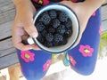 Little Girl Holding a Cup Full of Ripe Blackberries. Royalty Free Stock Photo