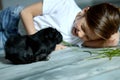 Little girl holding and feeding black guinea pig, domestic animal Royalty Free Stock Photo