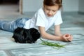 Little girl holding and feeding black guinea pig, domestic animal Royalty Free Stock Photo