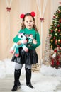 Little girl holding a unicorn in front of christmas tree Royalty Free Stock Photo