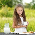 Little girl holding glass of milk outdoor summer Royalty Free Stock Photo