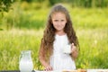 Little girl holding glass of milk outdoor summer Royalty Free Stock Photo