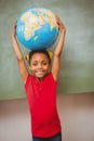 Little girl holding globe over head Royalty Free Stock Photo