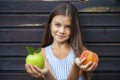 Little girl holding a green apple and a peach Royalty Free Stock Photo