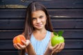 Little girl holding a green apple and a peach Royalty Free Stock Photo