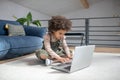 Little girl holding hands over laptop keyboard