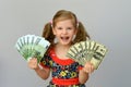 Little girl holding in hands a pack of dollars and Euro. Royalty Free Stock Photo