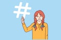 Little girl is holding hashtag symbol offering to use sign to tag friends in social media posts