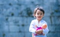 Little girl holding her doll, outdoor
