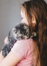 Little girl holding her new pet. Side view Royalty Free Stock Photo