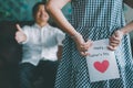 Little girl holding and hiding greeting card for father behind back.Concept of Happy father`s day Royalty Free Stock Photo