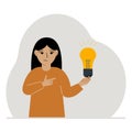 A little girl is holding a light bulb in his hand. Concept of idea, brainstorming, thinking, solution, eureka, bingo